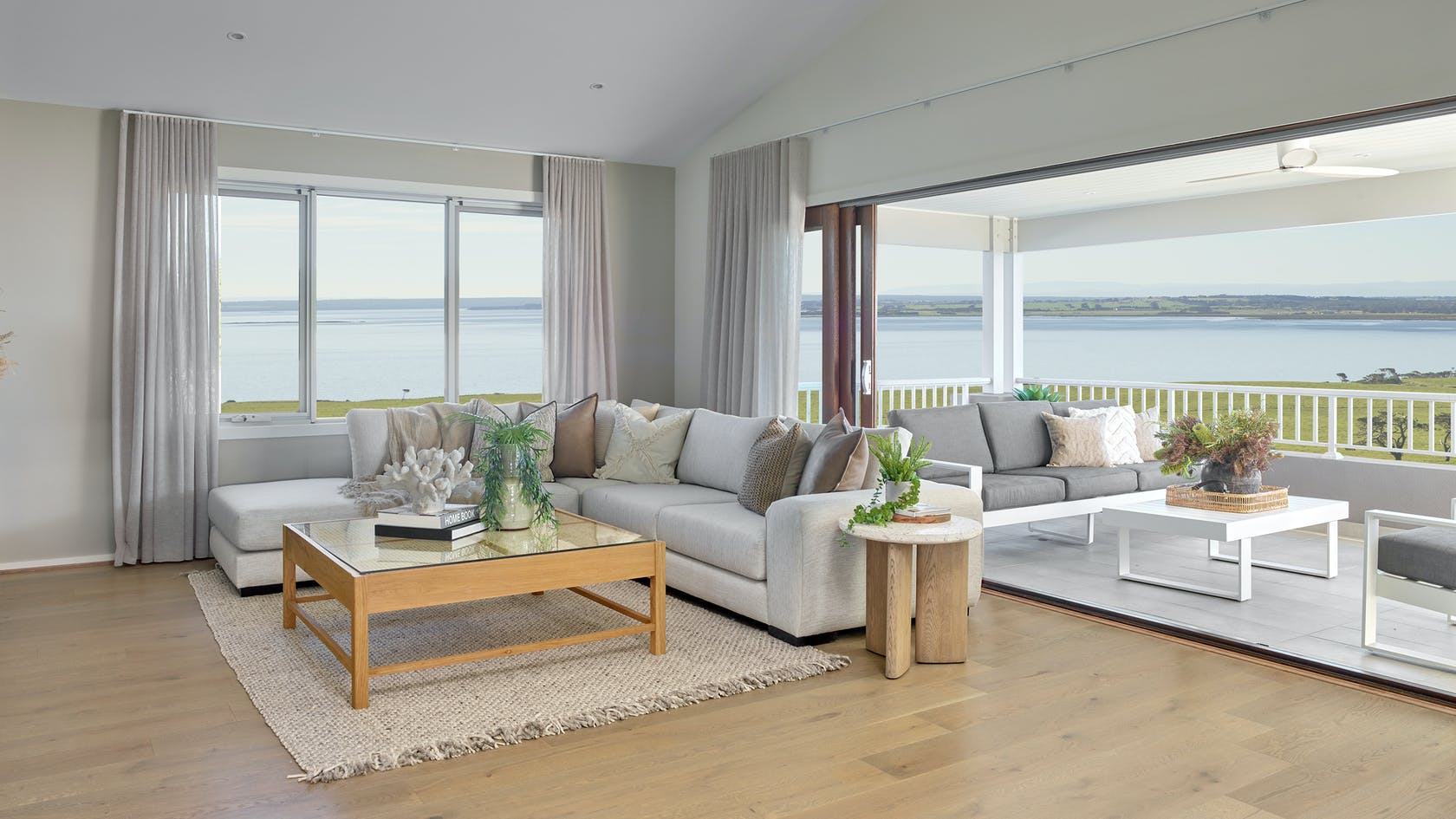 light grey sheer curtains in coastal living room with high ceiling