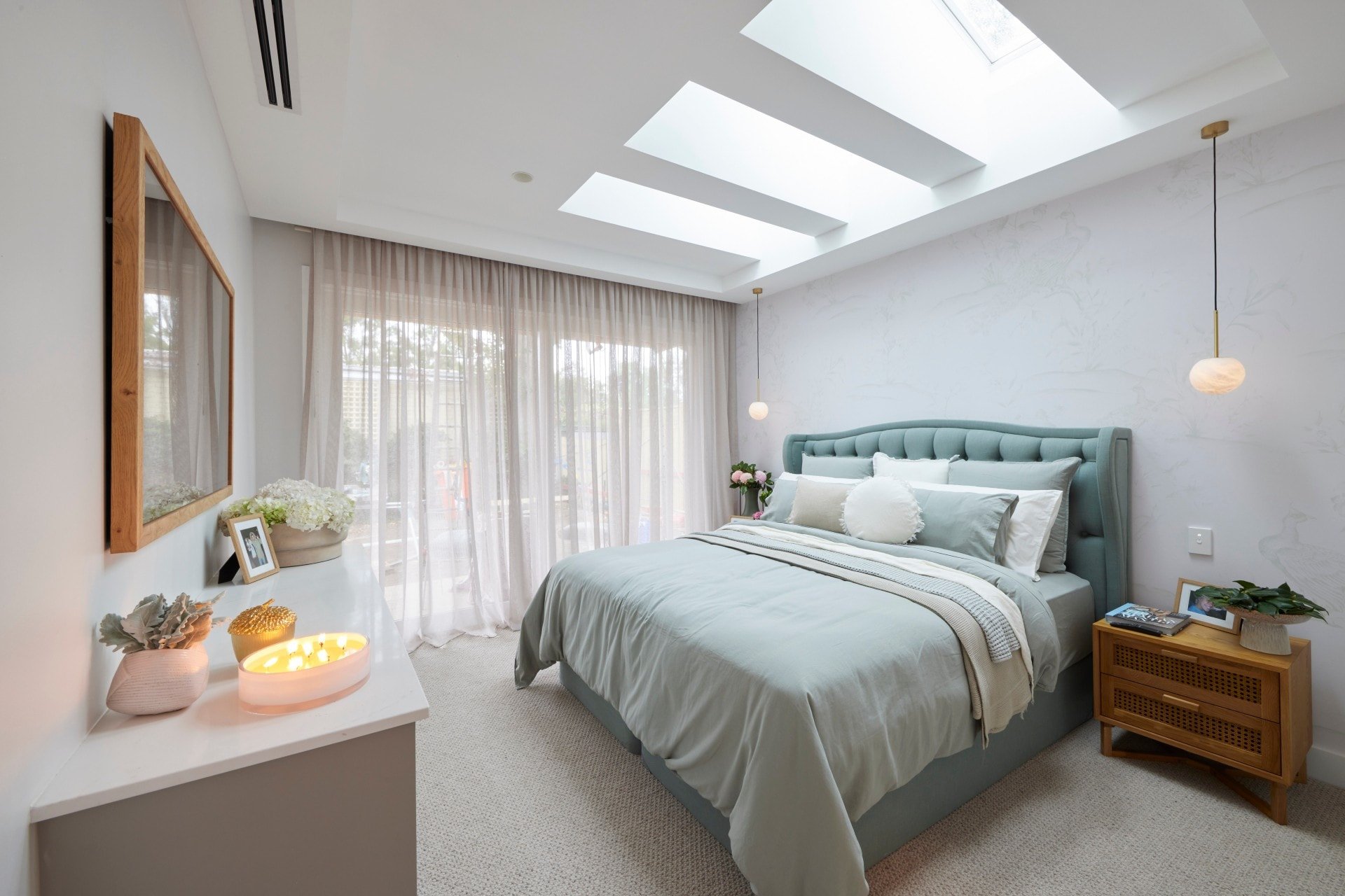 the block 2021 mitch and mark master bedroom with teal upholstered bed frame and skylights