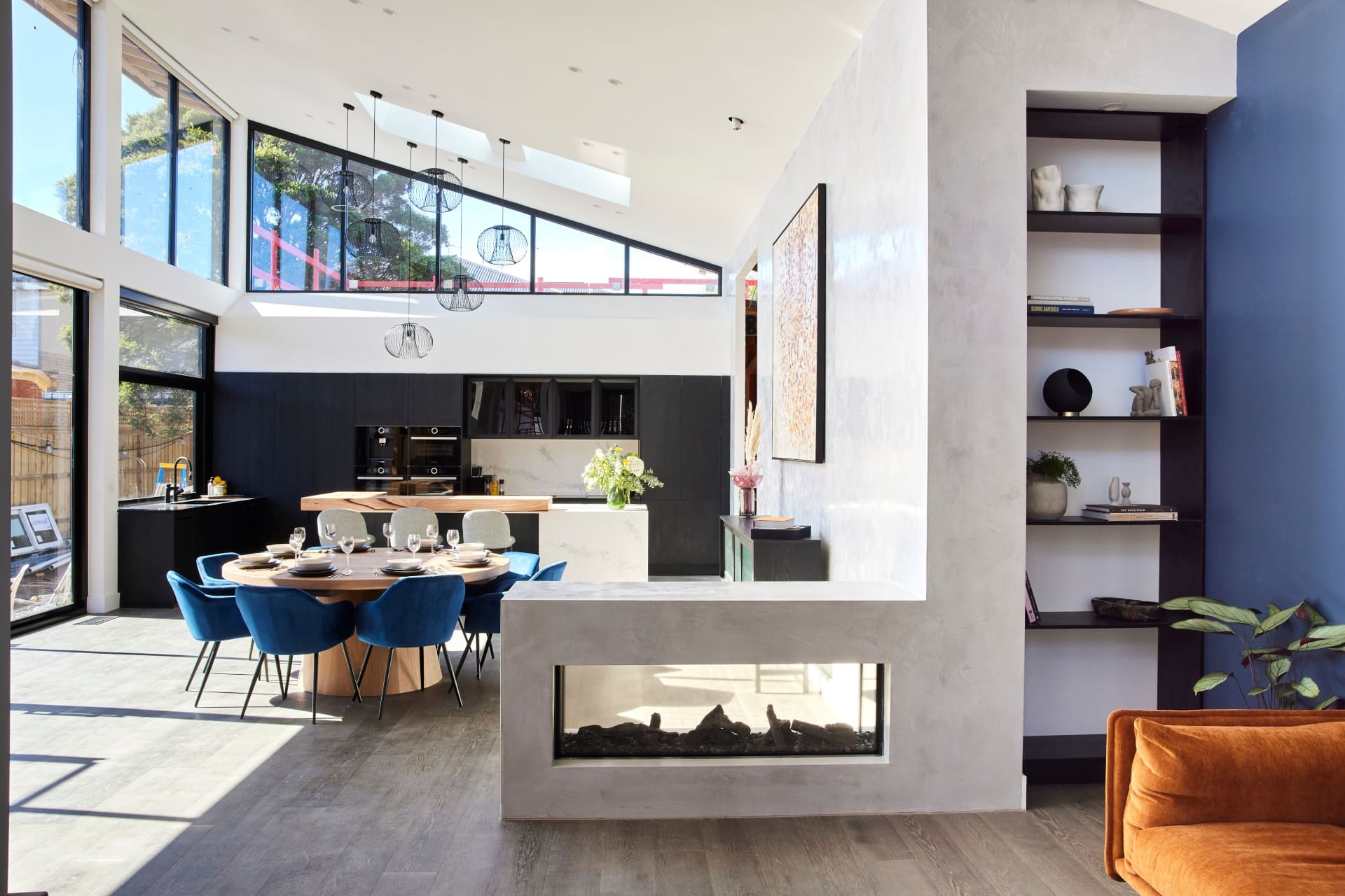 the block 2021 josh and luke living and dining room with gas fireplace grey feature wall