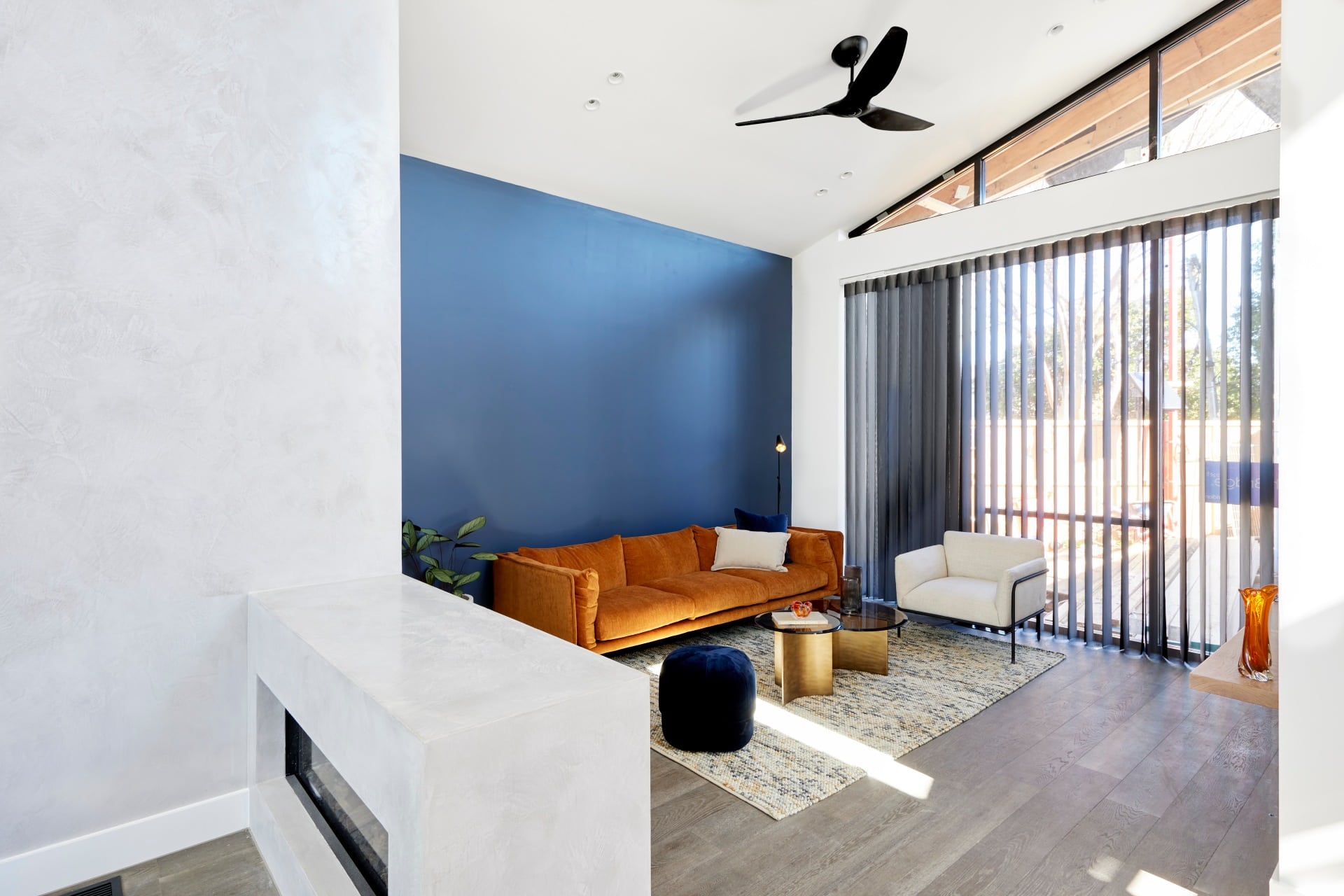 the block 2021 josh and luke living room with blue feature wall and orange sofa