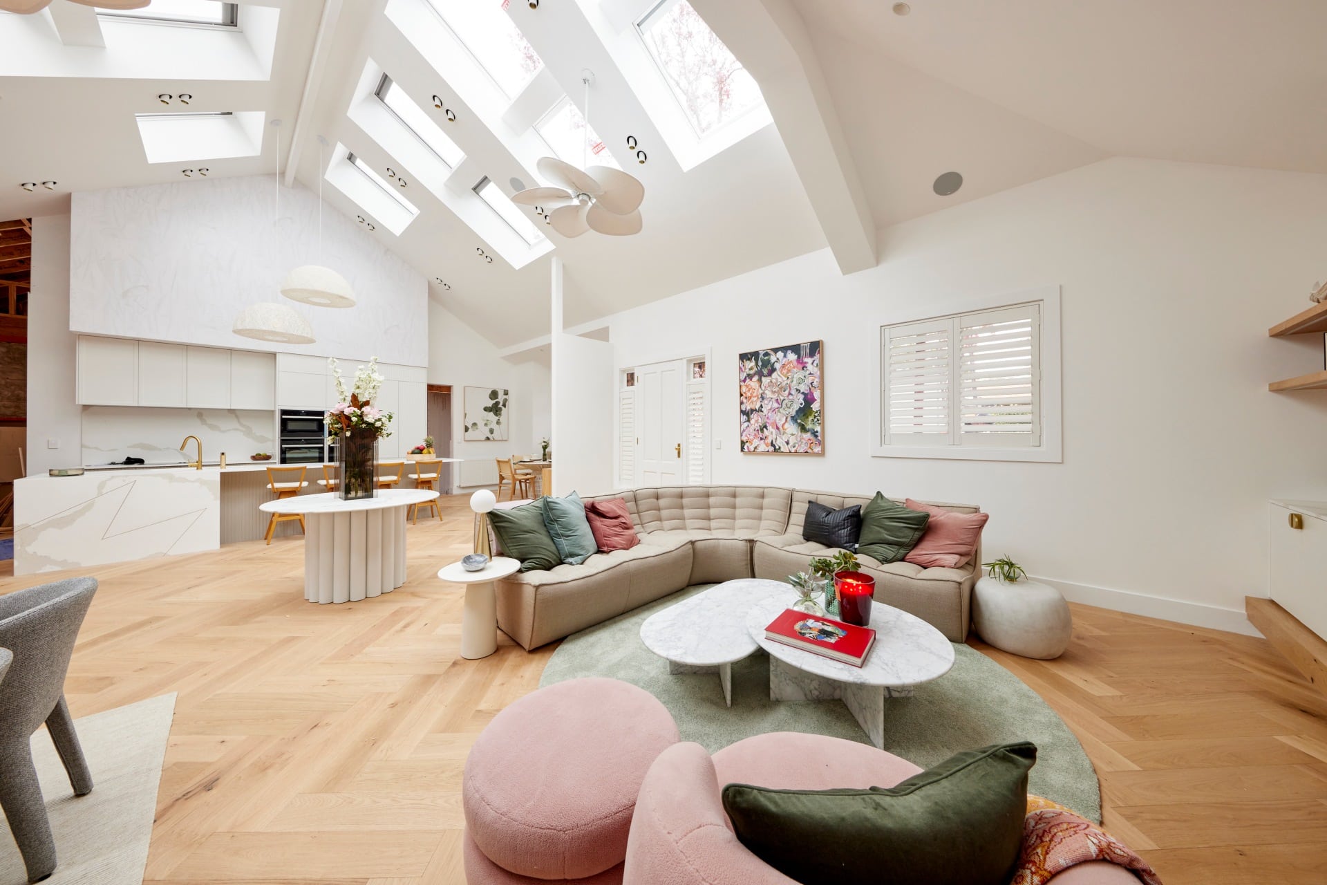 the block 2021 mitch and mark living and dining room with low grey sofa and round green rug
