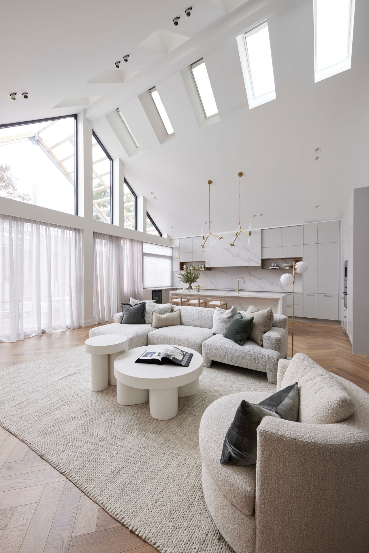 the block 2021 ronnie and georgia living room with white boucle sofa and pitched ceiling with skylights
