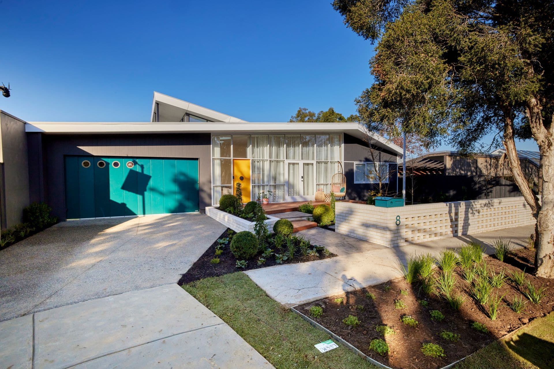 the block 2021 tanya and vito front yard mid century facade with yellow front door