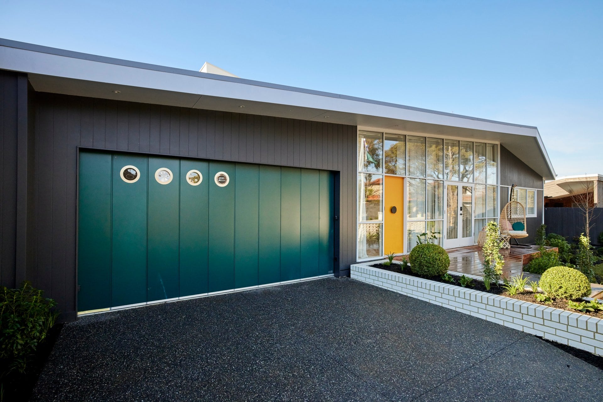 the block 2021 tanya and vito front yard teal garage door with round windows