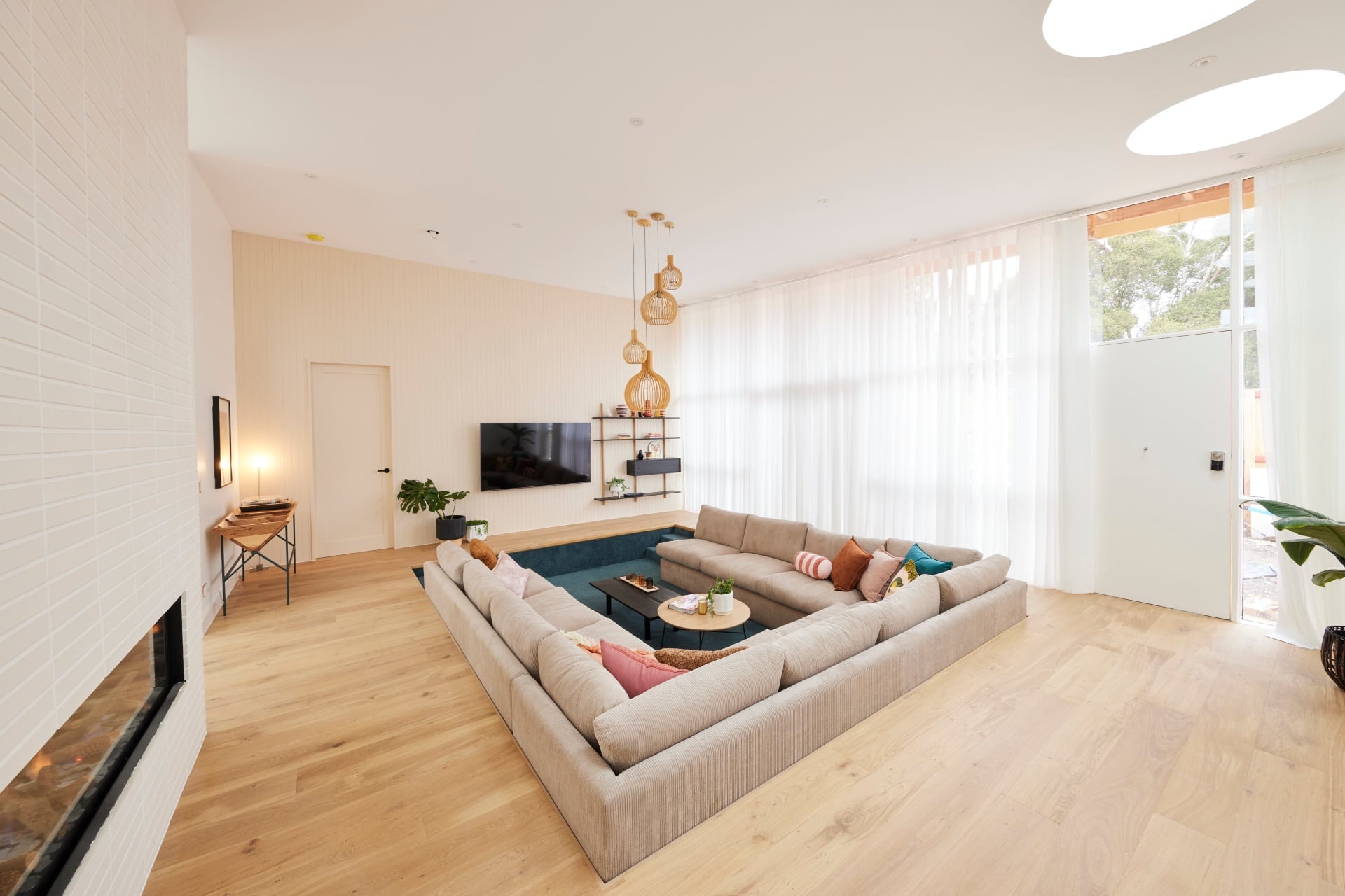 the block 2021 tanya and vito sunken living room with white brick fireplace