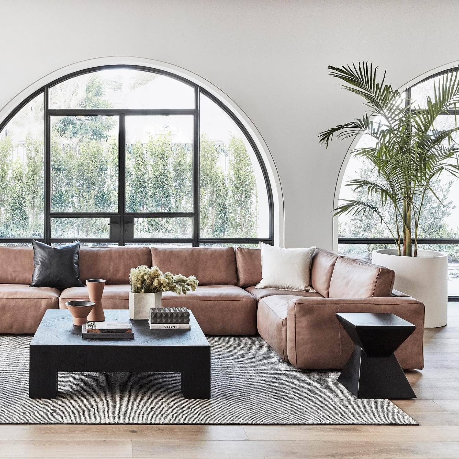 https://www.tlcinteriors.com.au/wp-content/uploads/2022/01/coco-republic-living-room-with-brown-leather-sofa-and-black-floor-rug.jpg