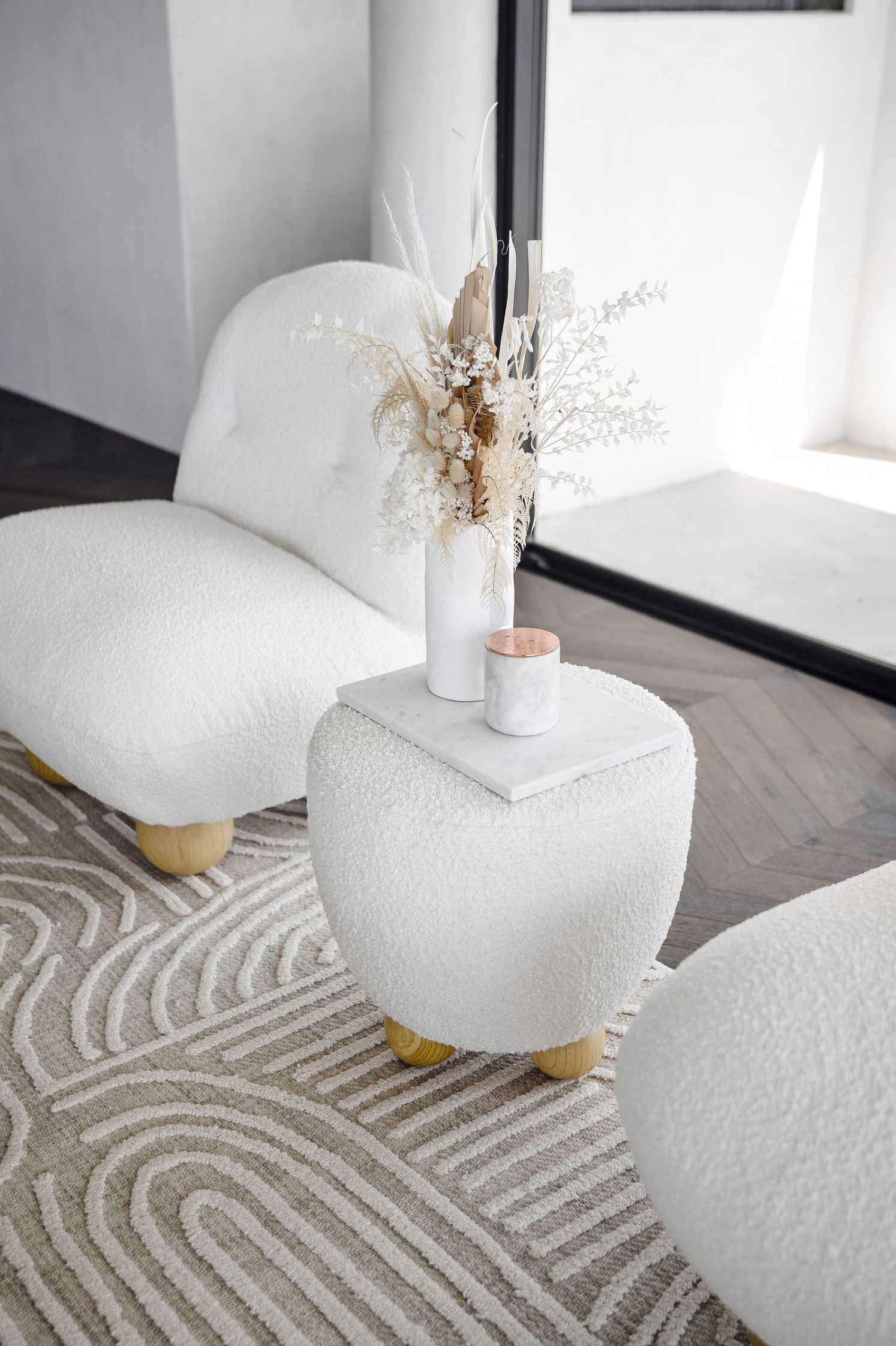 miss amara rug with white boucle armchair with timber legs
