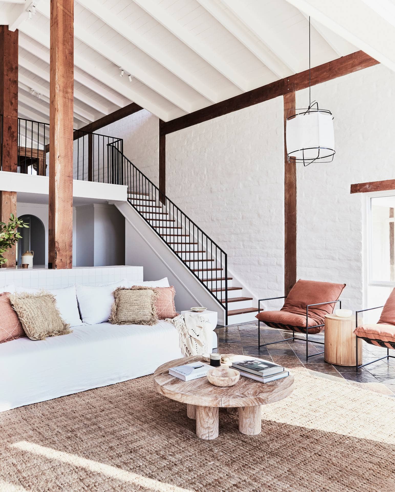 modern rustic farmhouse with white pitched ceiling timber beams and white sofa