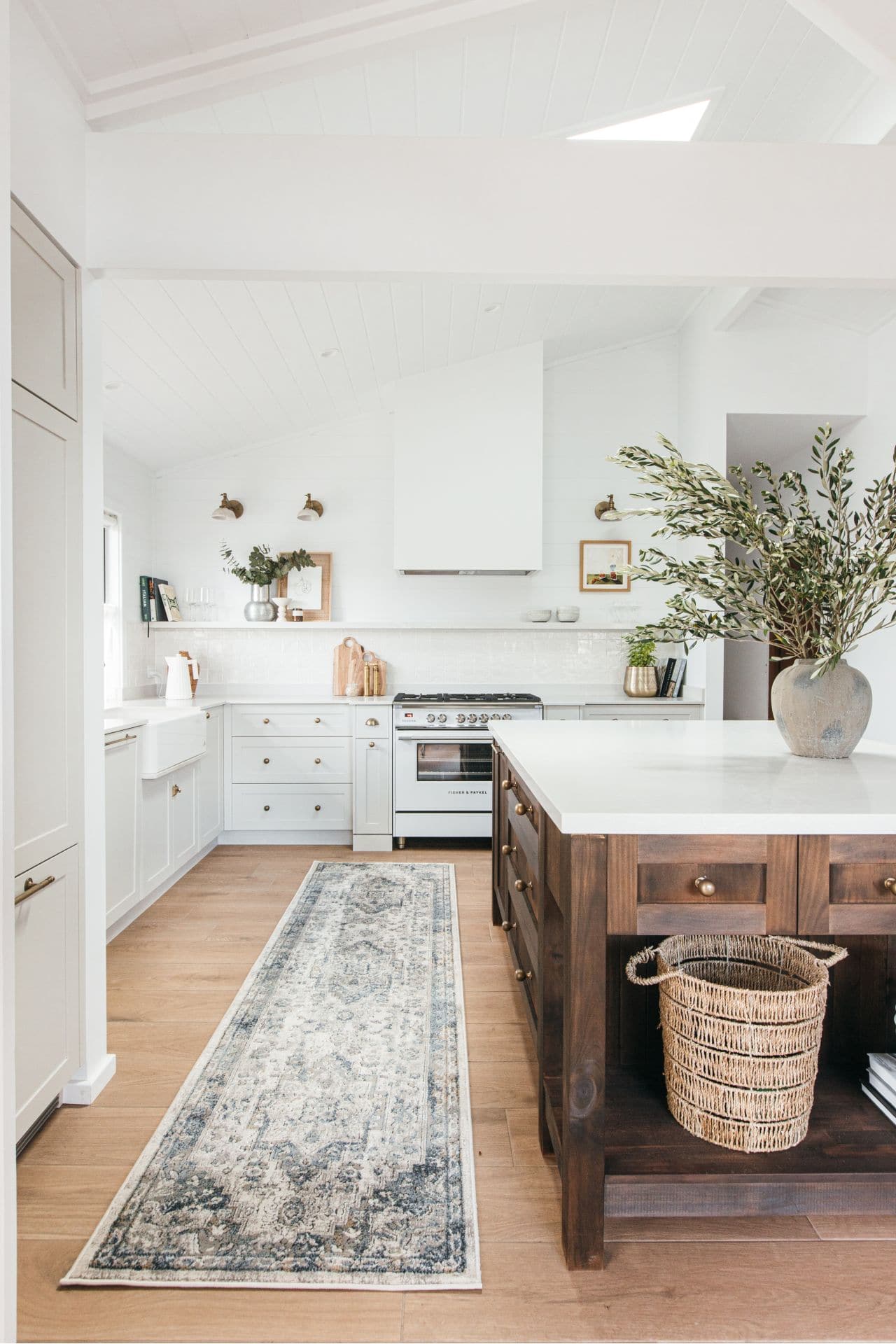 rustic kitchen with brass cabinet handles and pattern floor runner on timber floor