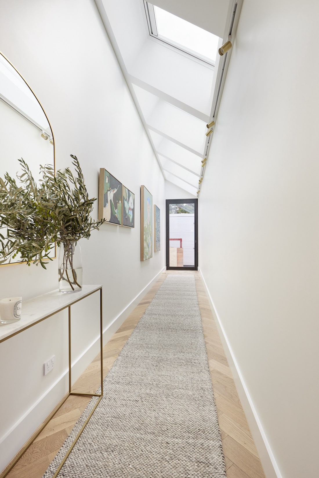 long hallway with hall runner and skylight
