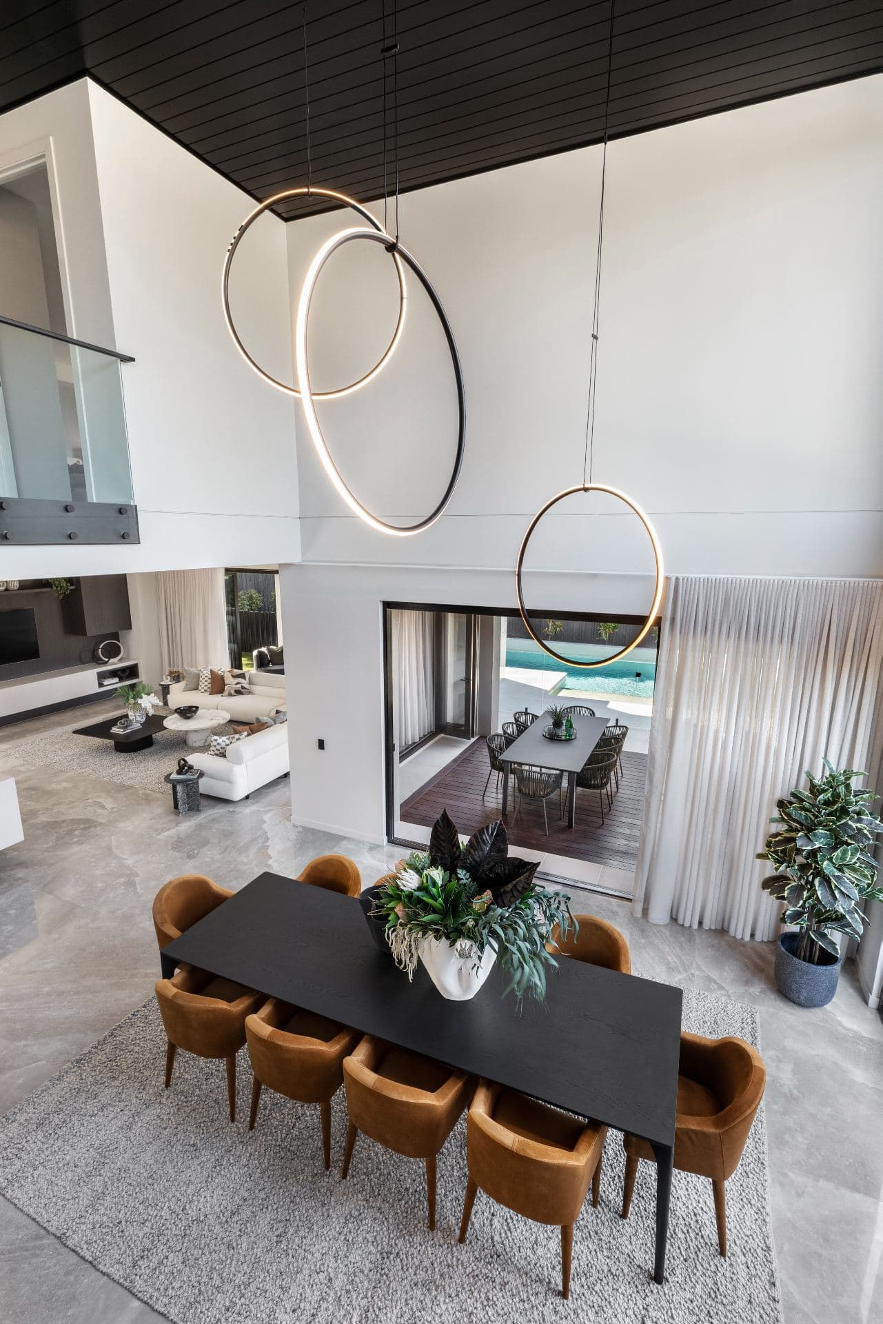 metricon lumiere display home dining room with ceiling void black dining table orange velvet dining chairs