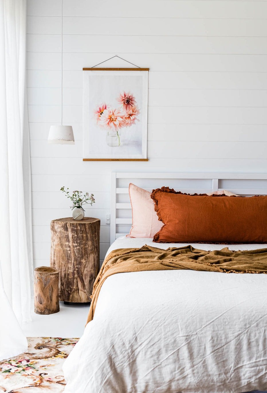 fabric wall hanging above bed in white rental bedroom home dweller