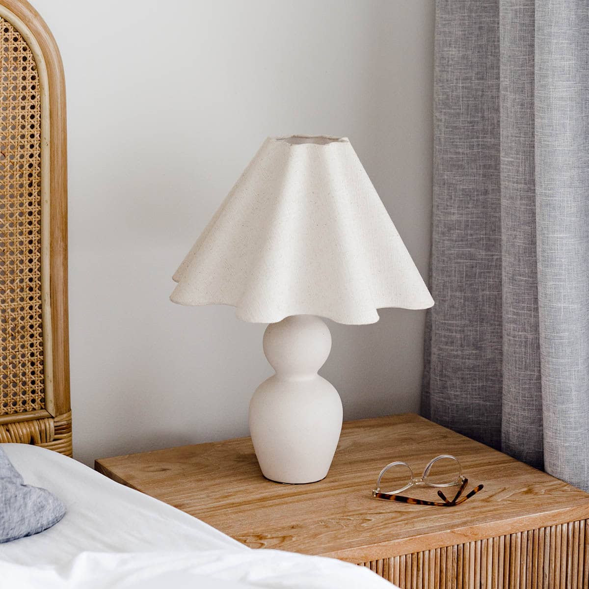 white lamp on rustic oak bedside table rattan headboard